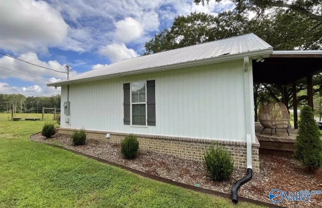 view of side of home with metal roof and a yard