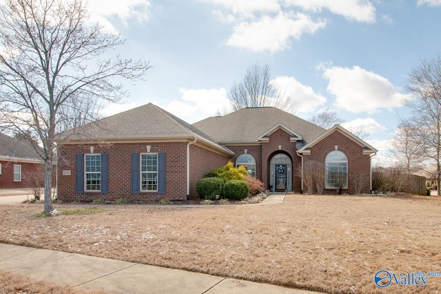 view of front facade featuring a shingled roof and brick siding