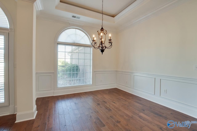 unfurnished dining area featuring dark wood-type flooring, a raised ceiling, a healthy amount of sunlight, and visible vents