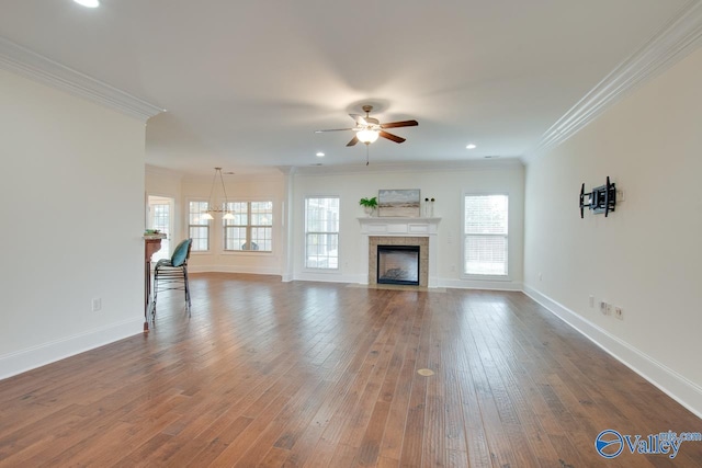 unfurnished living room with dark wood-style floors, ceiling fan, baseboards, and crown molding