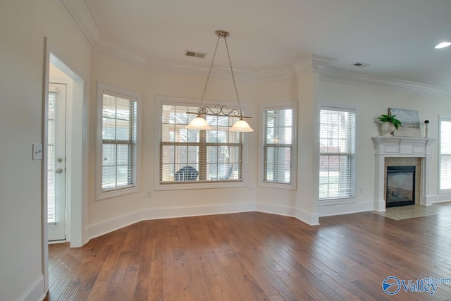 unfurnished dining area with wood finished floors, visible vents, and crown molding