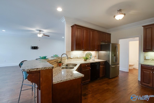 kitchen with a peninsula, a breakfast bar, a sink, stainless steel fridge with ice dispenser, and dishwasher