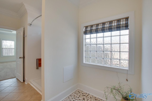 bathroom featuring ornamental molding, tile patterned flooring, baseboards, and walk in shower