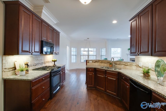 kitchen featuring decorative light fixtures, ornamental molding, a sink, light stone countertops, and black appliances