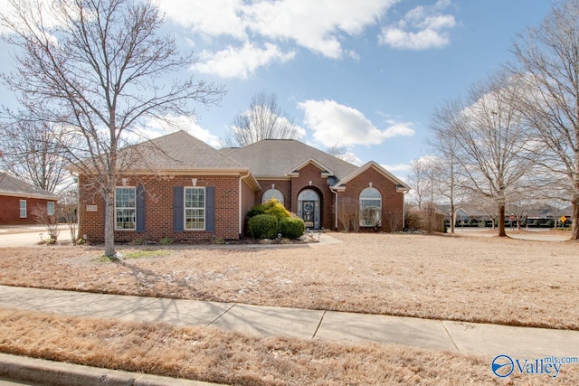 view of front of home with brick siding and a shingled roof