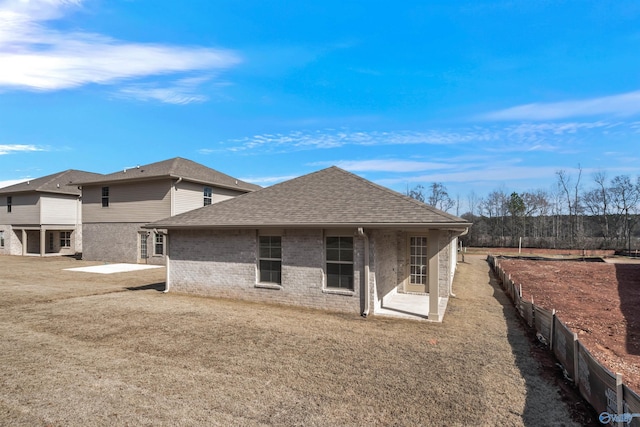 rear view of property featuring a patio and a yard