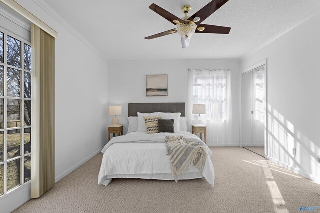 bedroom with ceiling fan, light carpet, a textured ceiling, and ornamental molding