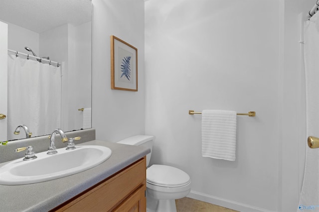 bathroom with toilet, vanity, and tile patterned flooring