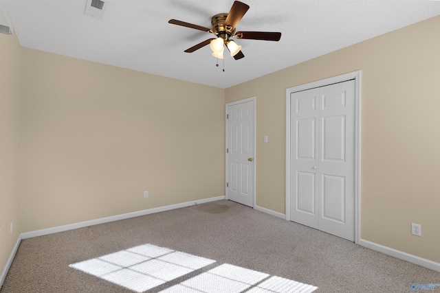 unfurnished bedroom with ceiling fan and light colored carpet