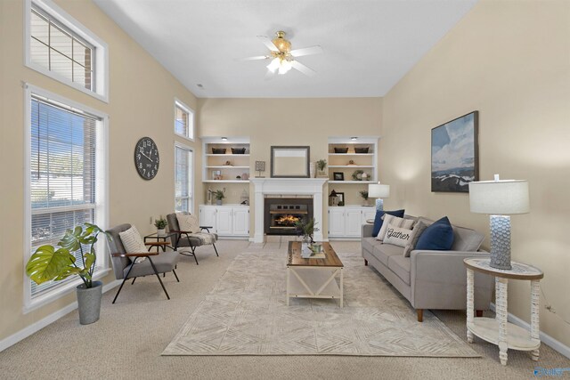 living room featuring ceiling fan, light colored carpet, and built in features