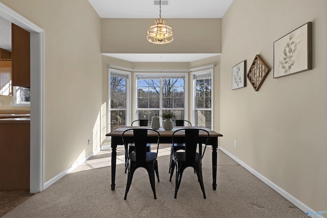 carpeted dining area with a notable chandelier