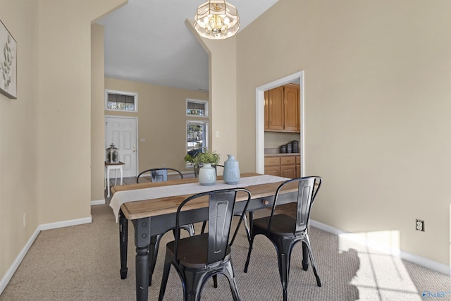 dining area with light colored carpet and an inviting chandelier