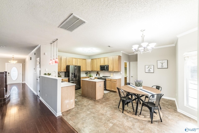 kitchen featuring stainless steel appliances, light countertops, visible vents, an inviting chandelier, and light brown cabinetry