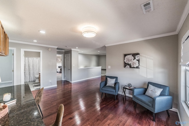 sitting room featuring baseboards, visible vents, wood finished floors, a textured ceiling, and crown molding