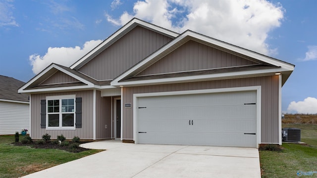 view of front of house featuring a garage, a front yard, and cooling unit