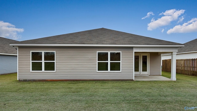 rear view of property with a yard and a patio area