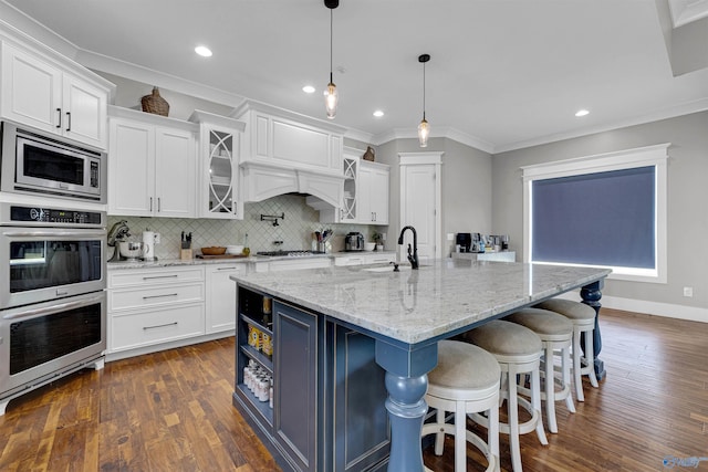 kitchen with stainless steel appliances, dark wood-type flooring, backsplash, ornamental molding, and premium range hood