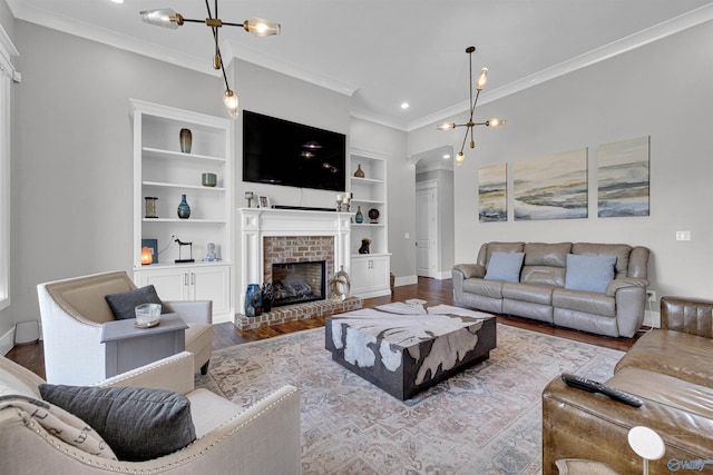 living room with hardwood / wood-style floors, a fireplace, ornamental molding, and built in features