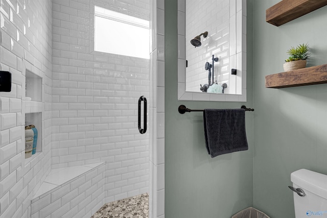 bathroom with a shower with door and toilet