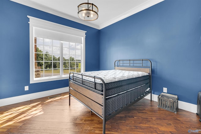 bedroom featuring crown molding and dark wood-type flooring