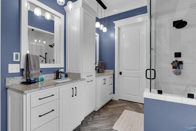 bathroom featuring an enclosed shower, vanity, and parquet flooring