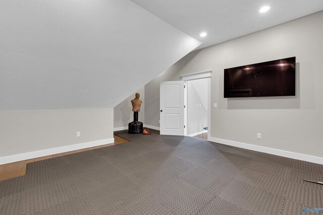 additional living space featuring carpet floors and vaulted ceiling