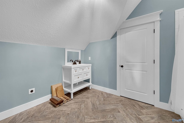 additional living space featuring light parquet floors, sink, a textured ceiling, and lofted ceiling