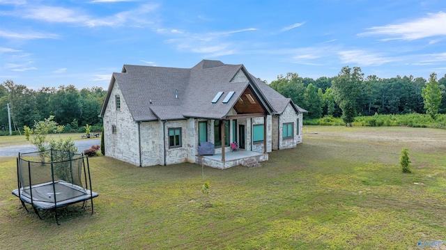 view of front of house featuring a front yard, a patio, and a trampoline