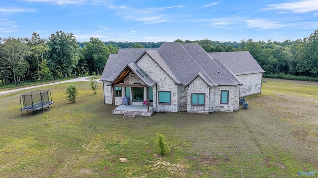 view of front of house with a front yard, a patio, and a trampoline