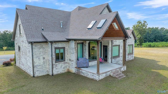 view of front of home featuring a front lawn and a patio