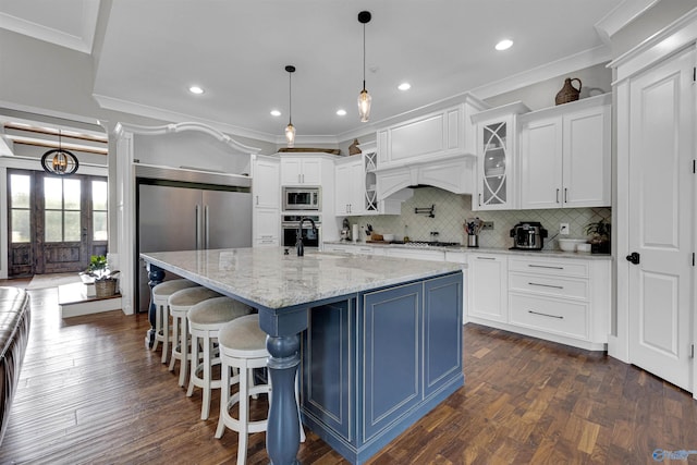 kitchen featuring tasteful backsplash, built in appliances, crown molding, hanging light fixtures, and dark hardwood / wood-style floors