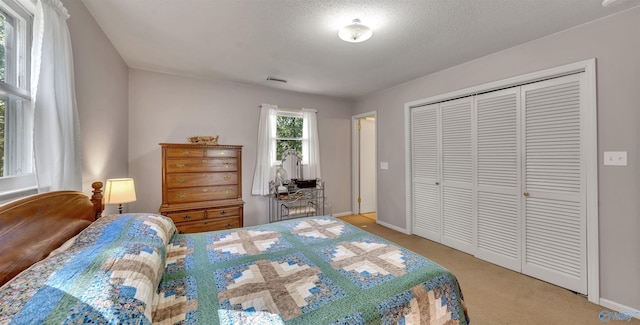 carpeted bedroom with a closet and a textured ceiling