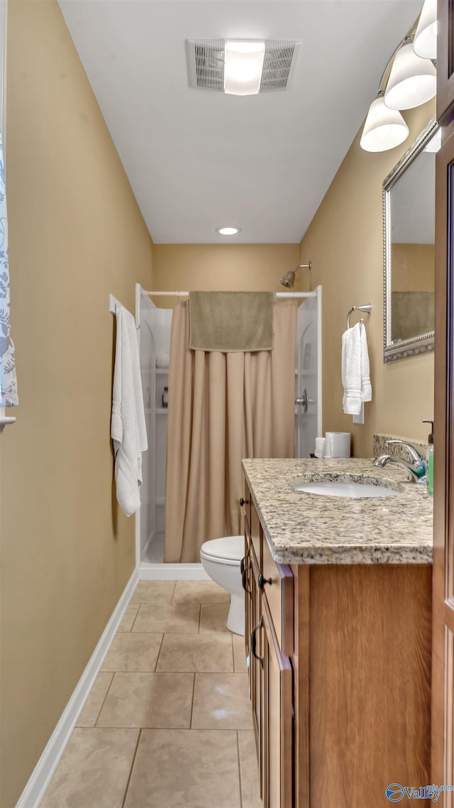 bathroom with toilet, vanity, tile patterned floors, and walk in shower