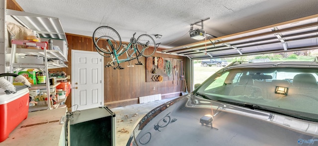 garage with a garage door opener and wood walls