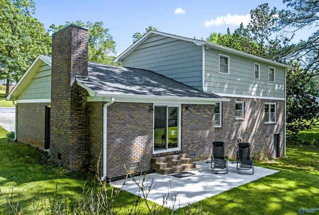 rear view of property with a patio and a lawn