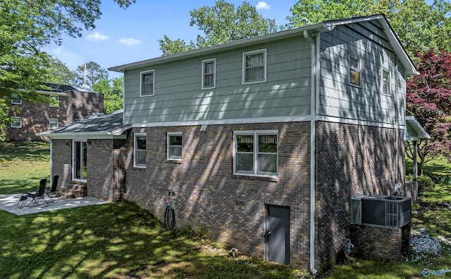 rear view of house featuring central AC, a patio area, and a lawn