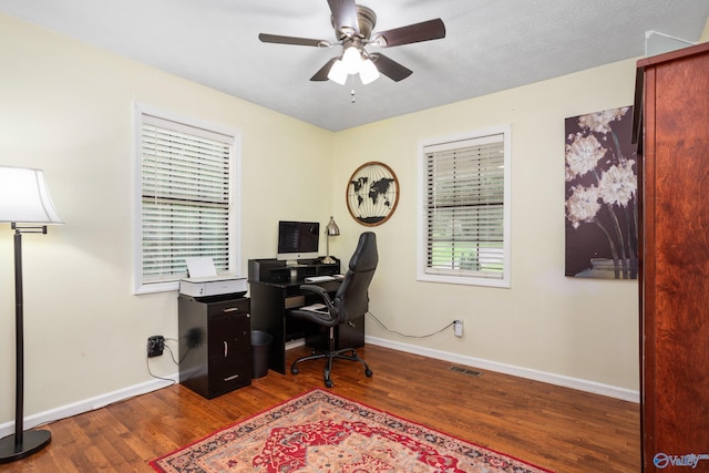 office with baseboards, visible vents, wood finished floors, and ceiling fan