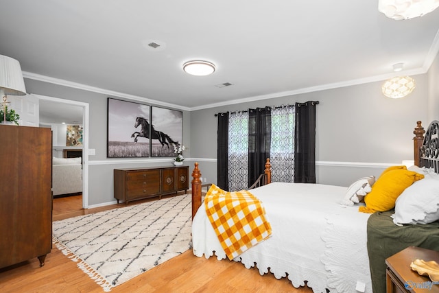 bedroom with ornamental molding and light wood-style flooring
