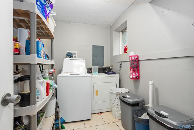 clothes washing area featuring tile patterned flooring, electric panel, washing machine and clothes dryer, and laundry area