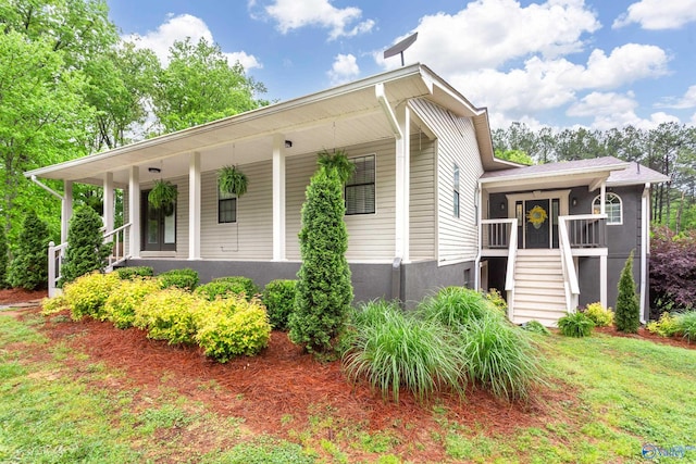 view of side of property featuring stairway and covered porch