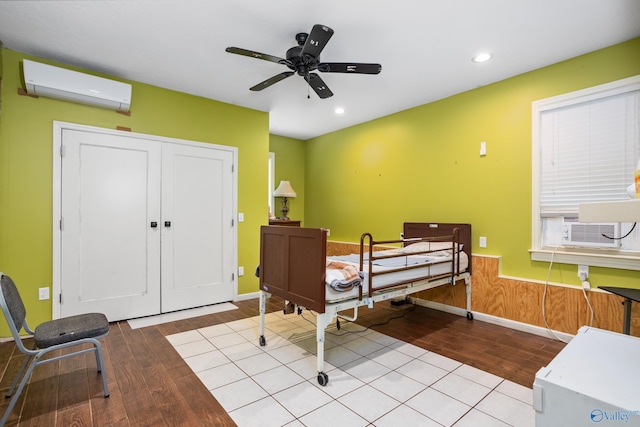 bedroom with recessed lighting, a wall mounted AC, wood finished floors, and baseboards