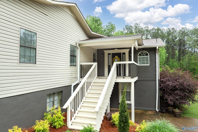 entrance to property featuring a shingled roof