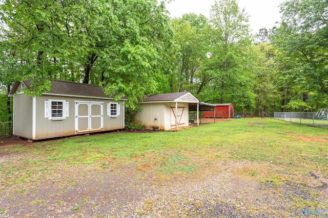 view of yard featuring an outdoor structure, a storage shed, and fence