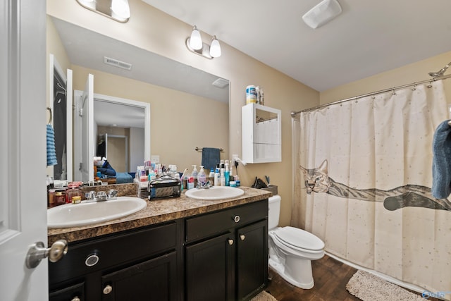 bathroom with wood-type flooring, vanity, and toilet