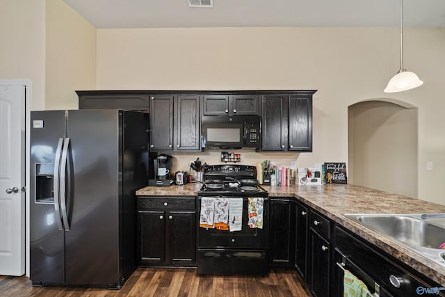 kitchen with pendant lighting, sink, dark hardwood / wood-style floors, black appliances, and kitchen peninsula