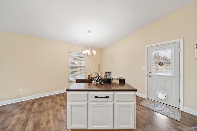 kitchen featuring pendant lighting, a notable chandelier, dark wood-type flooring, and white cabinets