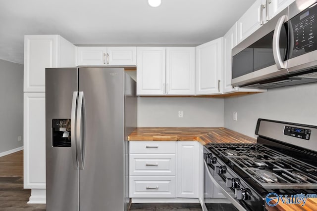 kitchen featuring appliances with stainless steel finishes, butcher block counters, and white cabinets