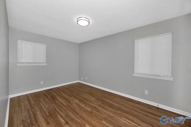 spare room with dark hardwood / wood-style flooring