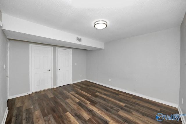 basement with dark hardwood / wood-style floors and a textured ceiling