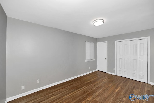 unfurnished bedroom featuring dark hardwood / wood-style flooring and a closet